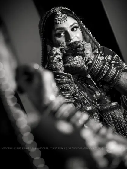 A classic black and white bridal portrait. This timeless style emphasizes emotion and detail, focusing on the bride's expression and the intricate mehndi on her hands.