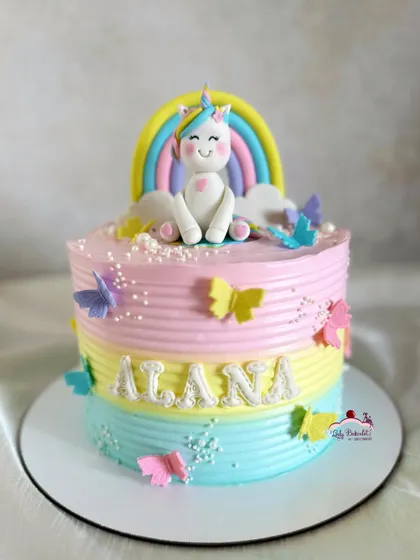 A beautiful pastel rainbow unicorn cake with a textured buttercream finish and delicate butterfly accents.