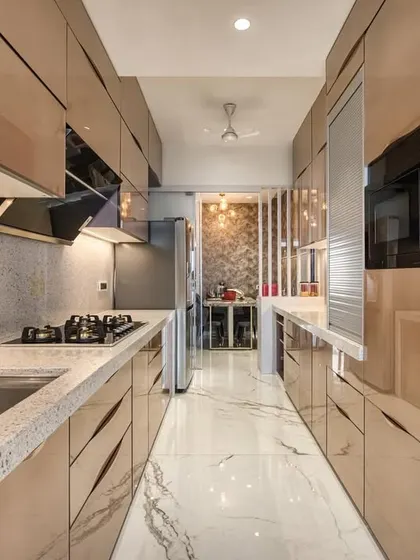 This parallel kitchen at JP Decks, Goregaon, features exquisite back-painted glass. The reflective surfaces and clean lines create a sense of spaciousness and modern luxury.