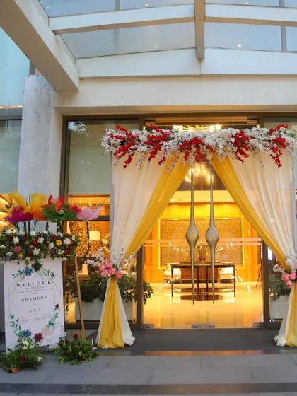 The grand entrance decor, featuring a welcome sign and an arch of flowers and drapes.
