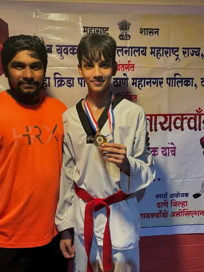 A picture with my student after his gold medal win at a district level Taekwondo event. The medal around his neck is a symbol of his hard work and our academy's commitment to excellence.