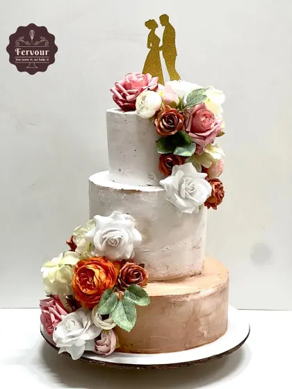 A grand 5kg three-tier cake for an engagement party. The design features a rustic textured finish in white and rose gold, adorned with a cascade of artificial flowers for a timeless and romantic feel.