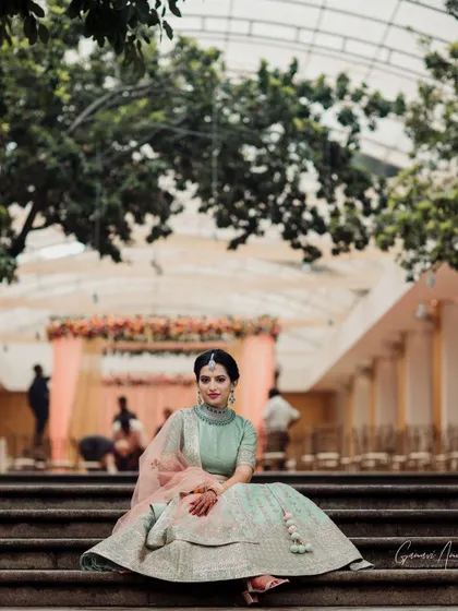 A wide shot showing the bride against the backdrop of her engagement decor. Her elegant makeup and hairstyle ensure she is the center of attention.