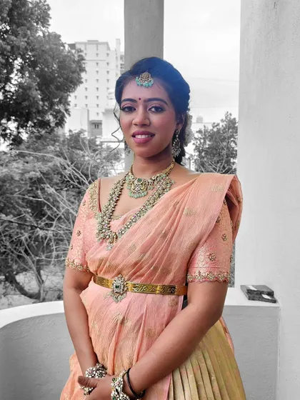 A black and white photo with a pop of color, highlighting Prakruthi's beautiful traditional attire.