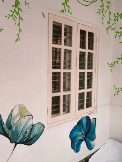 The combination of the hanging vines and blooming flowers makes the wall feel like a living garden.