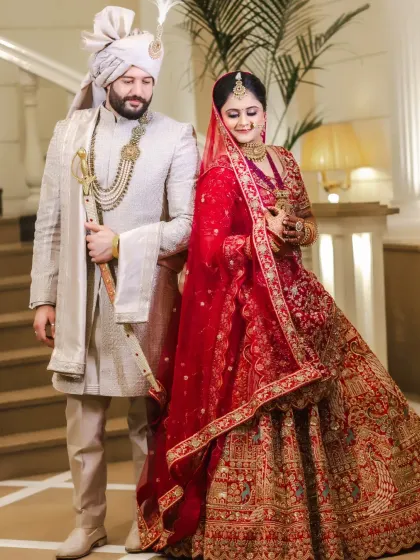 A full-length portrait of the couple, with the groom holding a traditional sword.