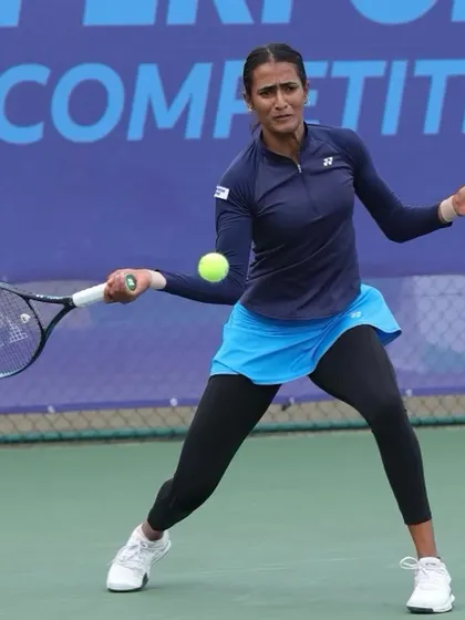 Rutuja hitting a clean backhand during a match. Her technique is a model of efficiency and power.