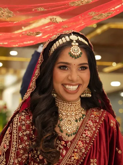 A radiant bride with a beautiful, wide smile, captured during her wedding ceremony.
