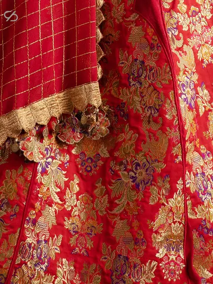 This detail shot highlights the rich texture and intricate floral patterns of the Banarasi fabric used in my red bridal lehenga, a testament to timeless Indian weaving traditions.