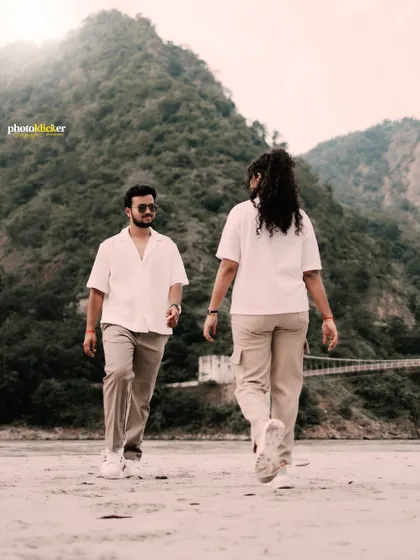 A classic walking shot of a couple on a sandy beach, capturing their relaxed and happy mood during their Rishikesh pre-wedding shoot.