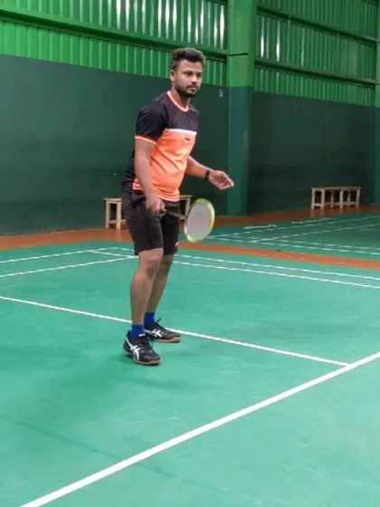 A solid ready stance is the foundation of good badminton. Our coach demonstrates the correct posture and racket position to prepare for any shot during a training session.