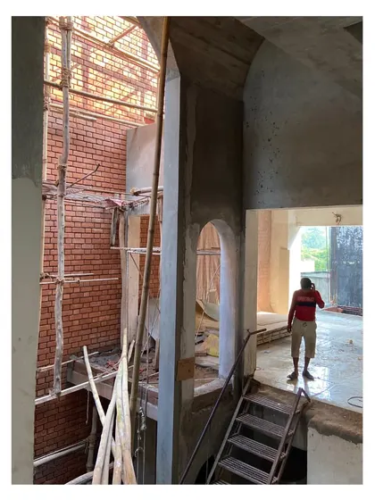 The harsh summer sun is filtered into soft light through the building's openings, creating serene shadows within the multi-height courtyard spaces.