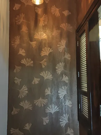 Another view of the ginkgo leaf stencil wall. This design is perfect for adding a touch of nature-inspired art to an entryway or living room.