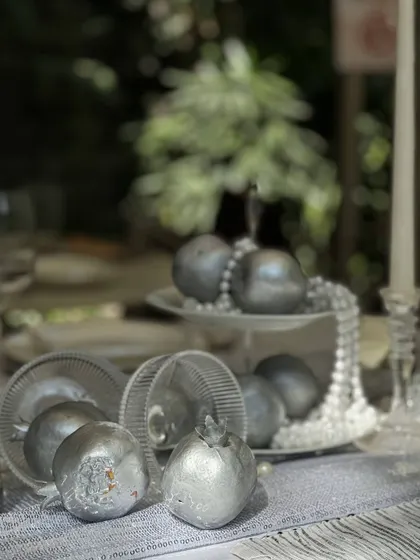 Another angle of the silver pomegranates and pearls, showing how these elements add a touch of unexpected glamour and texture to the table.