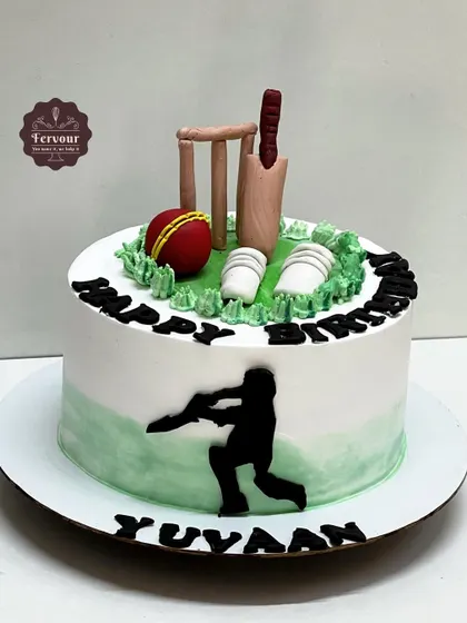 A simple and classic cricket theme cake. The design includes a fondant bat, ball, and wickets on a green frosting pitch, perfect for any cricket enthusiast.