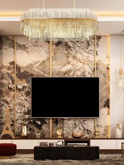 We designed this entertainment center with a mix of materials for a rich, textured look. The marble backdrop for the TV is flanked by vertical display shelves, perfect for showcasing art and decor, all illuminated by a stunning modern chandelier.