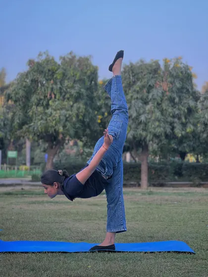 Practicing a standing split in the park. The fresh air and open space in Model Town add a special energy to our yoga sessions.