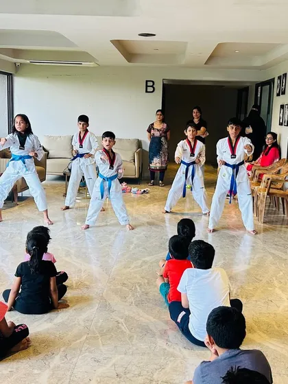 Students demonstrating their form in front of an audience of parents and younger kids, inspiring the next generation.