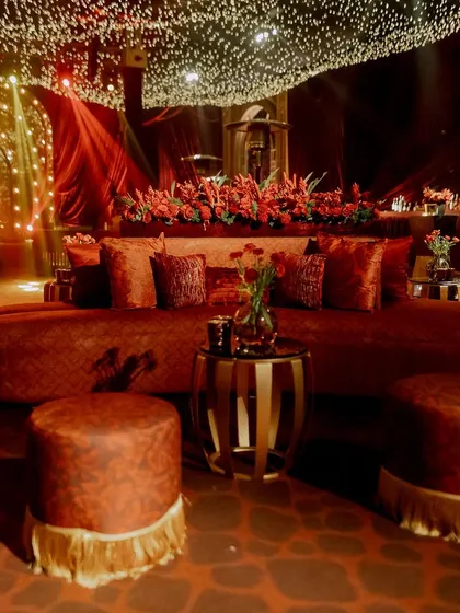 We designed intimate seating nooks with plush velvet sofas and ottomans. Each area was decorated with red floral arrangements and candles, providing comfortable and beautiful spaces for conversation.