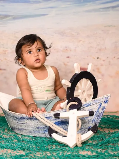 Explore our full nautical and beach-themed collection. These images showcase the variety of poses and angles possible with our boat prop, sand-colored flooring, and ocean backdrop.