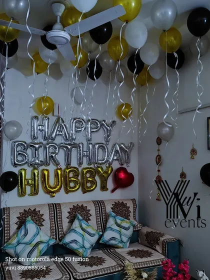 A fun surprise for a husband's birthday, this living room is decorated with black, gold, and white balloons. The 'HAPPY BIRTHDAY HUBBY' foil balloons make the message clear and personal.