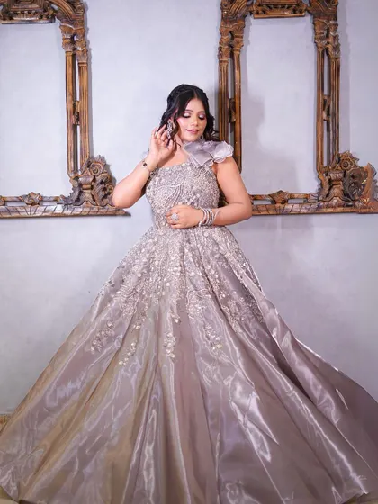 A full-length view of our grey satin gown with a unique floral shoulder detail and intricate beadwork.