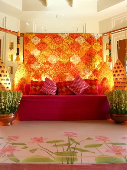 A vibrant indoor setup for a pre-wedding function in Rajasthan, featuring a colorful marigold backdrop and traditional seating.