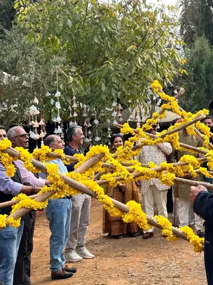 Family and friends coming together to create a festive pathway for the groom's entrance, a moment of unity and celebration.