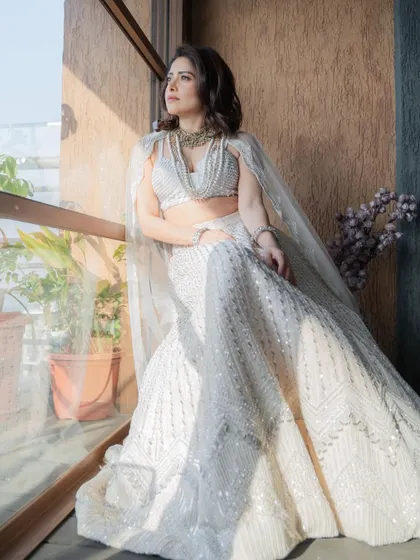 A full view of the ethereal ivory lehenga, showcasing its flow and intricate sequin work. A perfect inspiration for a modern bride's trousseau.