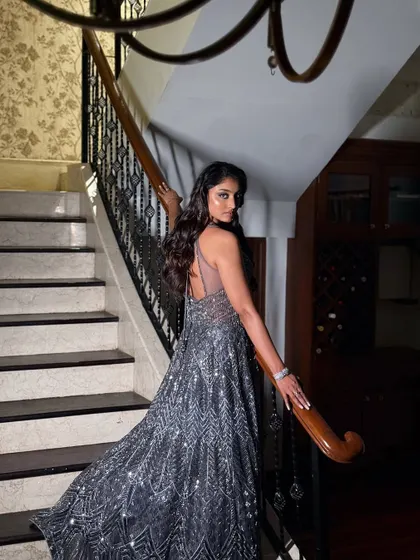 A beautiful shot showcasing the back of the gown and the soft waves in her hair. The entire look is cohesive, elegant, and ready for a grand entrance.