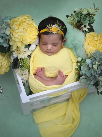 This overhead shot provides a full view of the floral crate setup, showcasing the beautiful arrangement of flowers and the peacefully sleeping baby.