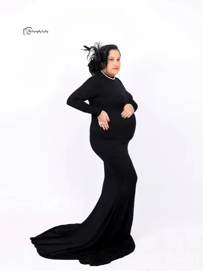 A classic silhouette portrait of a mother-to-be in a black gown, showcasing her beautiful baby bump.
