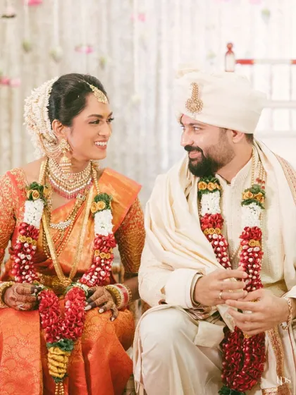 A beautiful portrait of the couple seated during their wedding ceremony. Their shared smiles and glances reveal their deep happiness and connection.