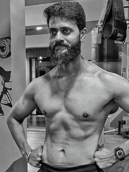 A black and white shot of the client, highlighting the muscle definition and confidence gained from his transformation.