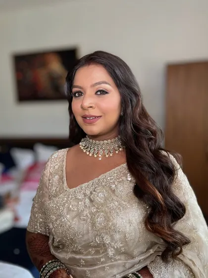A soft and elegant look for this bride in a silver-white saree. The makeup is subtle and glowing, with gentle waves in her hair.