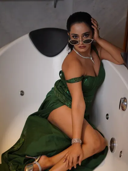 A classic, strong pose that combines glamour and attitude. The lighting is carefully controlled to highlight the sheen of the dress and the model's features.