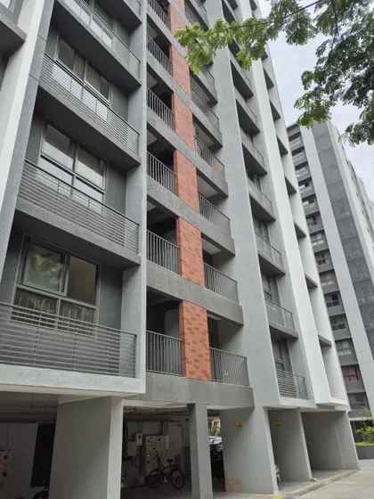 An angular view of the Adani Amogha building, showing the interplay of balconies and solid walls. This design choice provides privacy for residents while maintaining a cohesive and modern architectural expression.