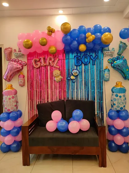 A fun setup for a gender reveal party. I created a split backdrop with pink and blue fringe curtains and balloons, with 'GIRL' and 'BOY' signs, letting everyone guess before the big reveal.