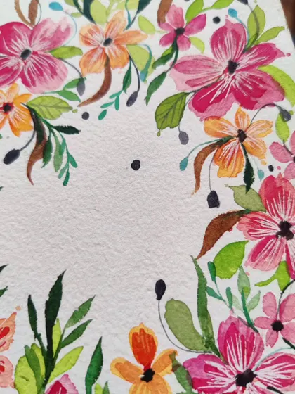 A close up of the top corner of the floral wreath, showing the mix of pink and orange flowers with varied leaf shapes.