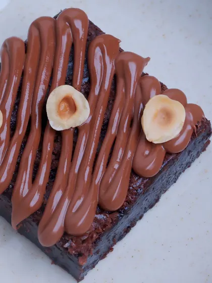 A tight shot of the Hazelnut Brownie, focusing on the texture of the spread and the perfectly roasted hazelnuts.