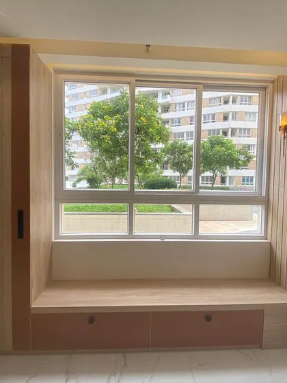 We love creating cozy corners like this window seat. It's the perfect spot to read a book or enjoy a cup of tea, with built-in storage drawers underneath and a stylish wall sconce for lighting.