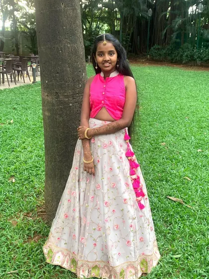 A full-length view of this floral lehenga set. The combination of the solid pink top and the delicately printed skirt creates a balanced and beautiful look, suitable for any celebration.