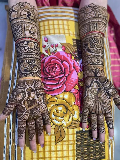 This stunning bridal mehndi features portraits of the bride and groom on the palms. The arms are decorated with bands of traditional patterns, including peacocks and wedding symbols.