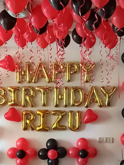A simple yet impactful birthday room decoration. Red and black balloons on the ceiling, paired with "Happy Birthday" foil letters, create a classic and bold look.