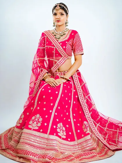 Seated pose showing the beautiful volume and intricate design of the rental lehenga skirt.