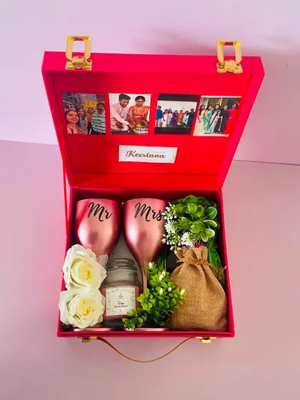 A "Bride to be" hamper in a vibrant red suitcase box. I've included personalized "Mr & Mrs" glasses, a scented candle, and other goodies, with photos on the lid.