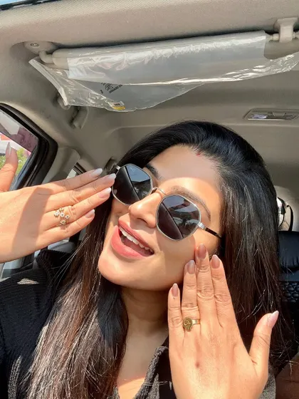 A joyful shot of a client highlighting her new nails. The natural finish and perfect shape give her hands a polished and elegant appearance.