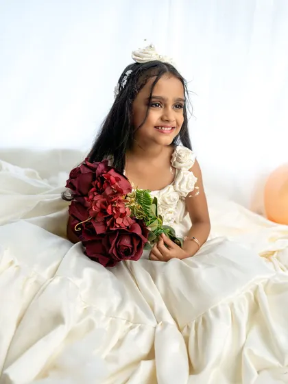 A candid, smiling shot of the birthday girl holding a bouquet. The natural light creates a beautiful, soft glow.