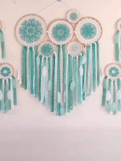This set of a large cluster dreamcatcher and matching smaller hangings was created to decorate an entire wall. The soothing sea green color brings a calming, cohesive vibe to the space.