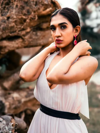 A powerful and confident portrait. The natural rock background adds a rugged texture that contrasts beautifully with her elegant gown.